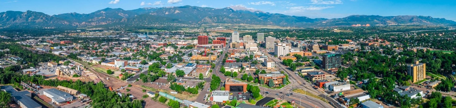 an aerial panoramic view of downtown Colorado Springs and Pikes Peak
