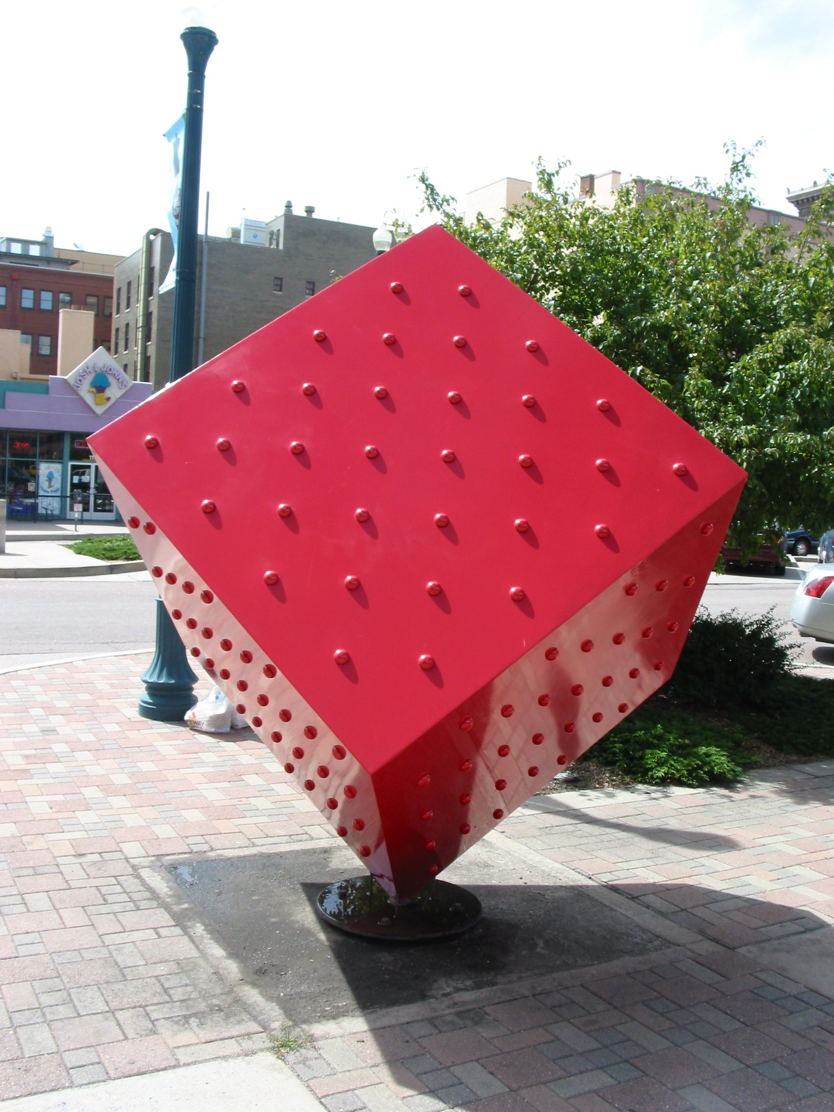 large red cube balancing on one corner