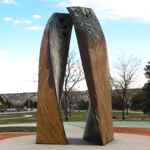 sculpture made of two large wooden columns standing side-by-side and curve slightly toward one another