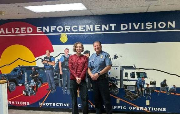 Jenna Rahal and Chief Adrian Vasquez smile for a photo together in front of Rahal's mural.