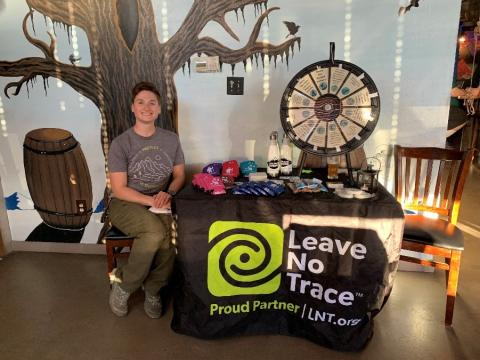 a person sits at a Leave No Trace booth at Storybook Brewing.