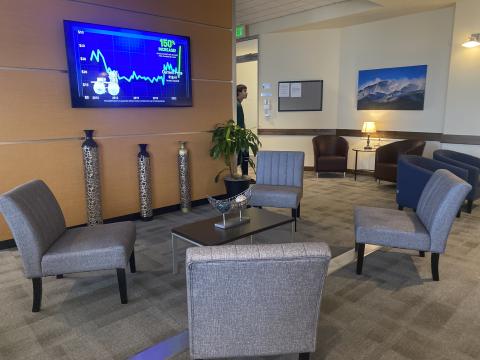 Photos of Colorado Spring Airport Premier Lounge; comfortable chairs around a table in front of a television