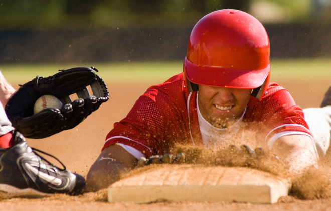 a man slides into a base beating the tag by a fraction of an inch