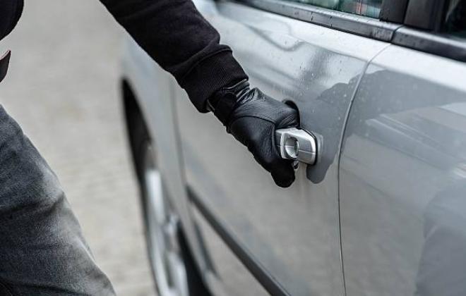 Person with Gloved Hand Reaching for Car Door Handle