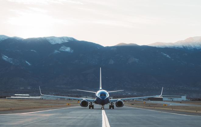 A plane on a runway at Colorado Springs Airport. The Front Range is visible in the background.