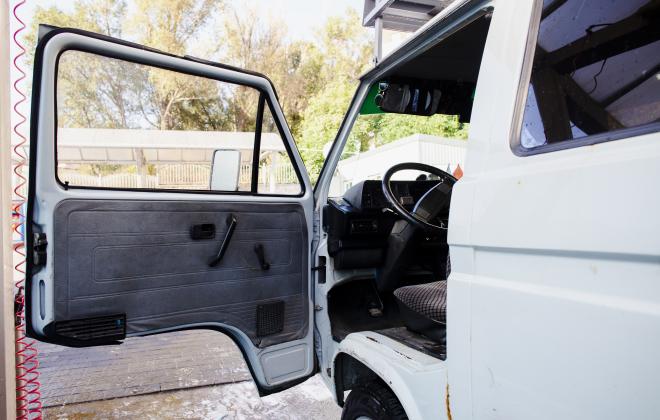 A white van, driver's side door is wide open. 