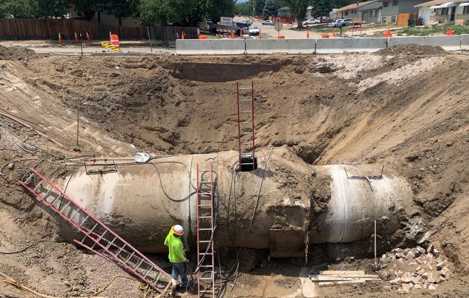 massive hole and cement pipe approximately 10-12 feet tall being installed underground 
