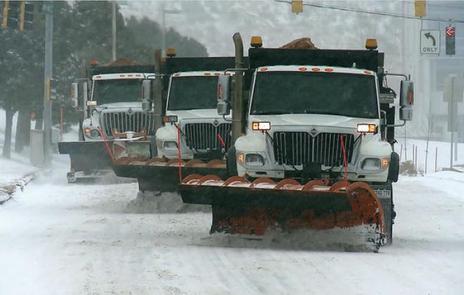 three snowplows plowing in tandum. 