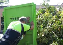 Code Officer helping close dumpster