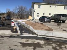 New concrete ditch to allow floodwater to drain from Cul-de-sac and apartment building